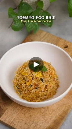 a white bowl filled with food sitting on top of a wooden cutting board next to a plant