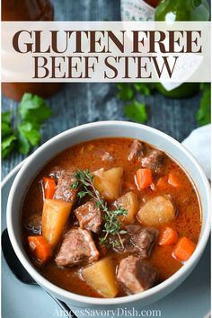 a bowl of beef stew with carrots, potatoes and parsley on the side