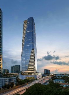 a very tall building in the middle of a city at dusk with cars passing by