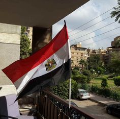 an egyptian flag flying on the balcony of a building