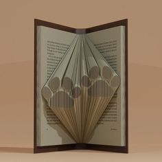 an open book with folded pages and circles on the front, in brown wood frame