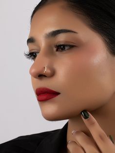 a woman with red lipstick and gold nose ring