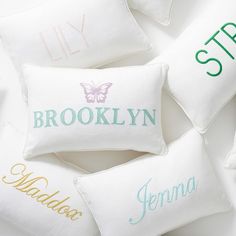 four personalized pillows with names on them sitting next to each other in a circle