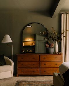 a living room scene with focus on the dresser and large mirror over it's top