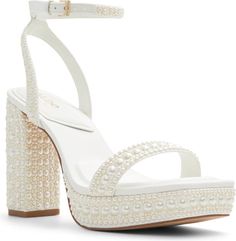 a white high heeled sandal with pearls