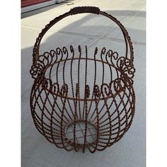 a wire basket sitting on top of a sidewalk