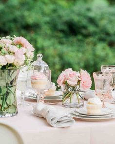 the table is set with pink flowers and cupcakes for an elegant wedding reception