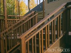 there is a wooden stair case on the outside of this house with trees in the background