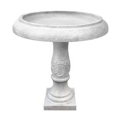 a white bird bath sitting on top of a cement pedestal with an ornate design in the center