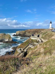 stairs lead down to the ocean with a lighthouse in the background