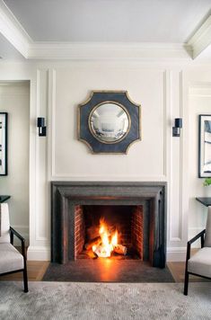 a living room with a fire place and chairs