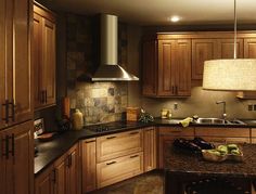 a large kitchen with wooden cabinets and granite counter tops, along with an island in the middle