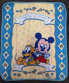 a mickey mouse blanket with a dog and stars on it's side, in blue and yellow