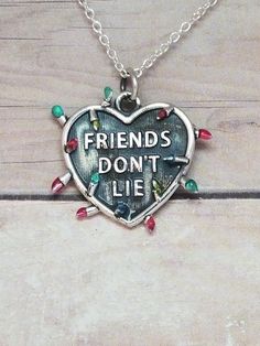 a heart shaped necklace with words on it that says, friends don't lie