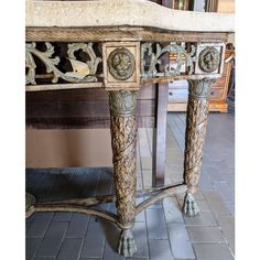 an ornately decorated console table with lion heads on it's legs and feet