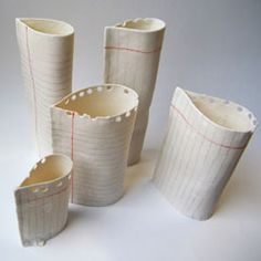 four white vases with red lines on them