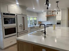 a kitchen with an island, sink and oven in the middle of the countertop