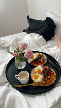 two breakfast plates on a bed with flowers