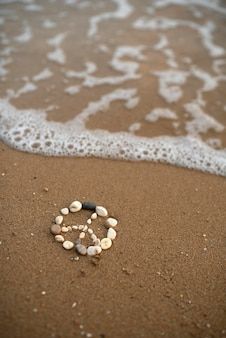 shells are arranged in the shape of a peace sign on the sand at the beach