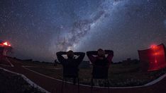 two people are looking up at the night sky