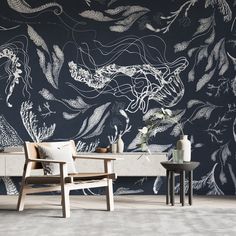 two chairs and a table in front of a wall with an artistic design on it