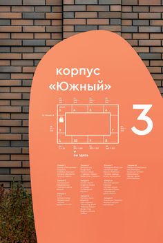 a large orange sign on the side of a brick building with numbers in russian and english