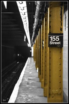 a black and white photo of a subway station with the number 156 street on it