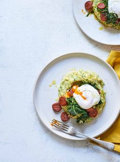 two white plates topped with food on top of a table