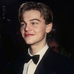 a man in a tuxedo smiles at the camera