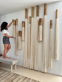 a woman is standing on a stool in front of some wall hangings