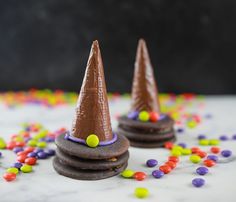 two cookies with chocolate frosting and colored candies around them on a marble surface