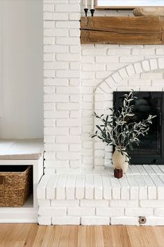 a white brick fireplace with a potted plant on the mantle