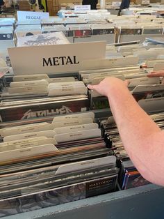 a man pointing to metal records in a record store