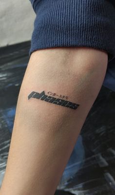 a person with a tattoo on their arm and the word mountain written in black ink