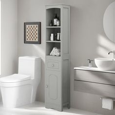 a white toilet sitting next to a sink and a tall cabinet in a bathroom near a window