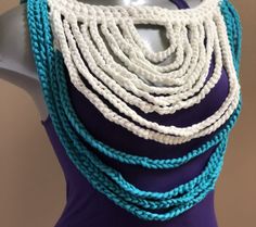 a white and blue necklace on top of a mannequin