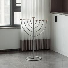 a tall metal menorah sitting on top of a counter next to a window