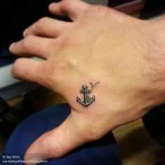 a small anchor tattoo on the left wrist