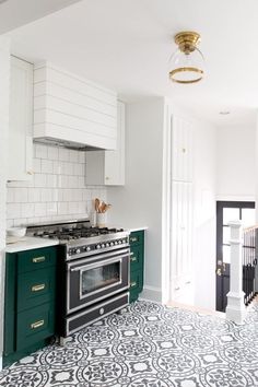 a kitchen with green cabinets and white walls