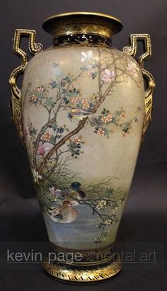 an ornate vase with birds and flowers painted on the side, sitting against a black background