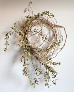 an arrangement of branches and flowers hanging on a wall