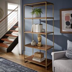 a living room filled with furniture and a stair case in front of a blue wall