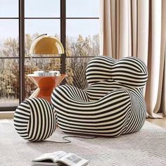 a black and white striped chair sitting on top of a rug next to a window