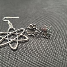 These earrings are made and modeled by women in STEM! Silver color atom earrings, with bonus atom studs. If you have a double-piercing, these would look super cute together! The hooks for the atom dangle earrings can be metal alloy or hypoallergenic 925 sterling silver. Check out the matching necklace in my shop! Atom Earrings, Atom Symbol, Chemistry Jewelry, Stem Earrings, Gear Earrings, Pyrite Earrings, Women In Stem, Double Piercing, Science Jewelry