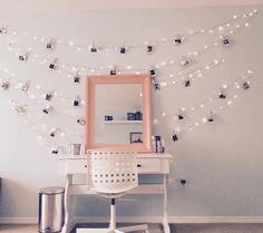 a white desk with a mirror and lights on the wall above it in a room