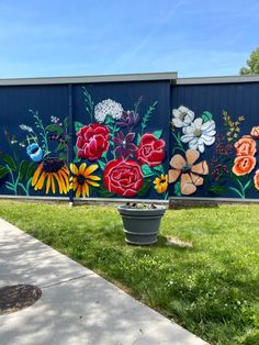 This mural is painted on a blue background. There are colorful wildflowers and garden variety flowers on it. Wild Flower Mural Wall, Floral Mural Art, Gospel Graffiti, Wall Murals Painted Outdoor, Garden Mural Outdoor Wall Art, Chicken Trailer, Outdoor Mural Ideas, Star Mural