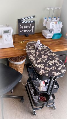 an ironing board sitting on top of a wooden desk next to a sewing machine