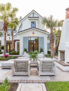 a white house with blue shutters and palm trees