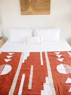 a bed with a red and white bedspread on top of it