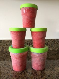 four plastic cups are stacked on top of each other in the middle of a counter